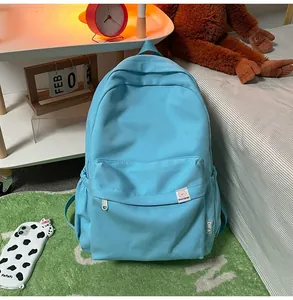 Close-up of sky blue corduroy school backpack with front pocket and branded patch