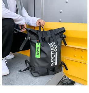 Detailopname van een zwarte roll-top rugzak met witte letters en een groen label