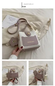 Détails du sac seau bicolore mauve et blanc avec breloque fleur et sangle