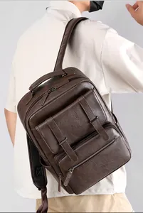 Close-up of brown pebbled PU leather backpack with multiple zipper pockets and straps