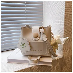 Détail du sac seau beige avec boucle en bois et accessoire de charme en nuage