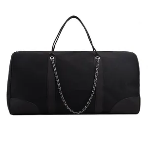 Detailed view of black canvas travel tote with silver chain and leather reinforced edges
