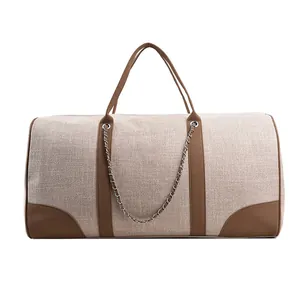 Large beige canvas tote bag with brown leather trim and silver decorative chain