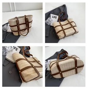 Detail view of woven straw tote bag with brown leather trim and gold rivet accents