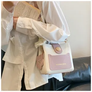Détail du sac seau bicolore blanc et violet avec breloque fleur et bouton en bois