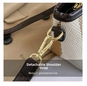 Detail of detachable shoulder strap with gold hardware and brown leather trim on canvas bag