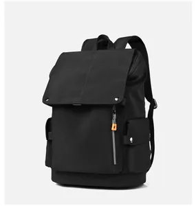 Detail of black flap backpack with orange zippers and metal buckles for travel
