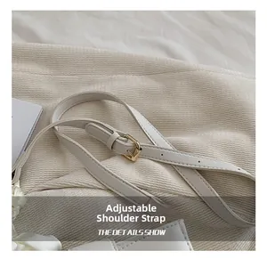 Détail de la bandoulière réglable en cuir PU blanc avec boucle dorée et surpiqûres fines