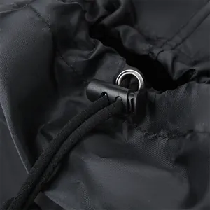 Detail of black nylon backpack featuring durable drawstring, spring buckle, and metal ring