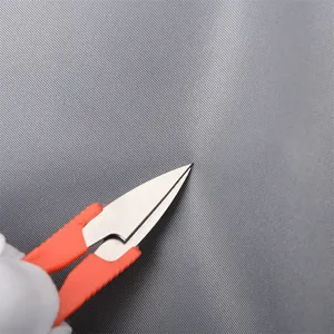 Close-up of fine stainless steel mesh being cut with scissors to show material durability