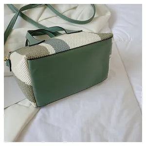 Detail shot of green leather bottom and woven pattern on the striped bucket bag