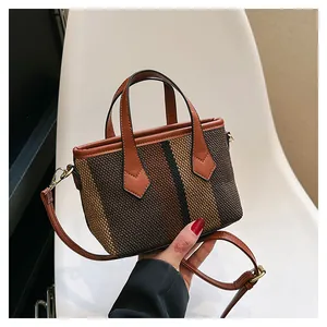 Close-up of striped knit fabric texture and premium brown faux leather handles