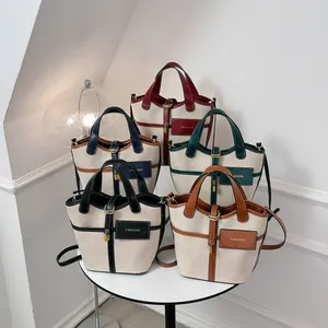 Minimalist canvas bucket bags in five colors with leather trim and shoulder straps