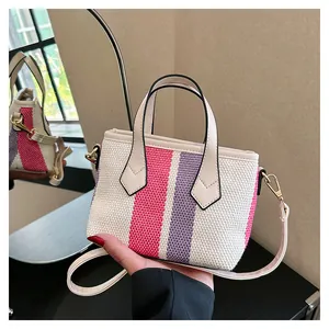 Detail of pink and purple striped mini tote bag with white handles and gold hooks