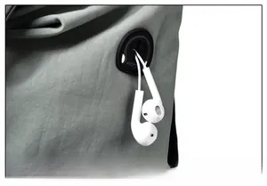 Close-up of circular rubber headphone port on a grey textured fabric backpack detail