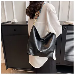 Large black Hobo shoulder bag with colorful geometric woven strap and smooth leather texture