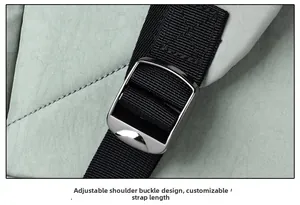 Detail of adjustable shoulder strap with silver metal buckle on light green travel backpack