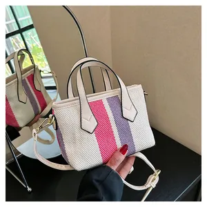 Detailed close-up of woven canvas bag showing pink and purple stripes with gold hardware