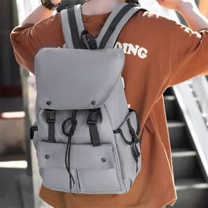 Macro shot of grey utility nylon backpack with flap buckle and drawstring closure on a model