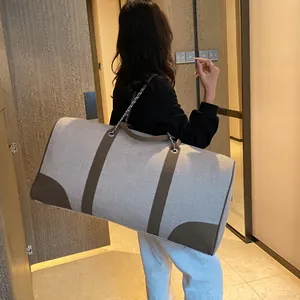 Large capacity canvas travel tote with gray fabric and brown leather straps on model