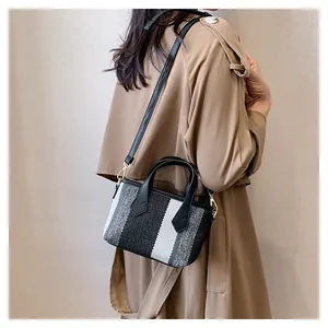 Detail of striped canvas mini bag styled on model with cross-body strap and woven texture