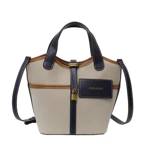 Vintage canvas bucket bag with navy leather trim and gold lock pendant for women