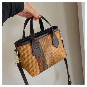 Close-up of woven bucket bag featuring striped texture and leather strap details