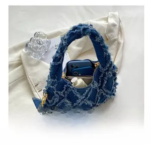 Blue denim handbag capacity detail showing two phones, wallet and skincare items