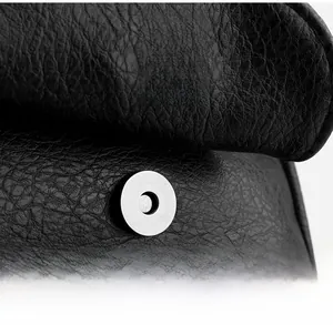 Detailed macro view of silver magnetic snap closure on black lychee grain leather bag