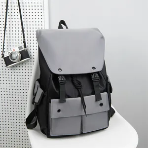 Detail of grey and black nylon backpack featuring buckle closures on a white chair