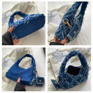 Close-up of distressed denim handbag with fringe details and a small matching coin purse