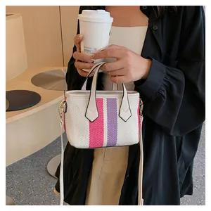 Detailed close-up of striped canvas handbag featuring pink and purple vertical color blocks