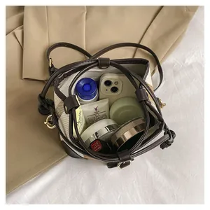 Detail of striped bucket bag showing spacious interior with phone and cosmetics