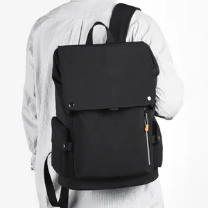 Black flap backpack with orange zipper accents shown worn on back for daily commute
