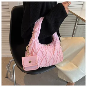 Detailed texture of pink frayed denim hobo bag with matching mini zipper pouch accessory