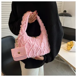 Detail of pink denim handbag featuring distressed frayed stitching and matching coin purse