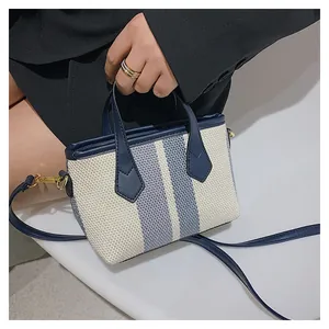 Detail of blue and white striped canvas bucket bag with premium leather handle and strap