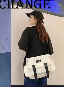 Vue latérale d'un sac messager beige avec poche latérale et boucle en plastique
