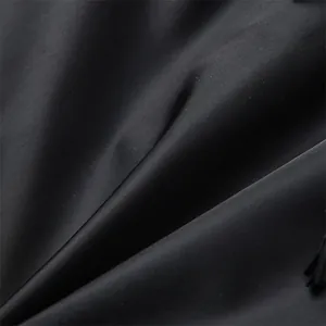 Macro shot of durable black nylon fabric showing fine weaving texture and smooth finish