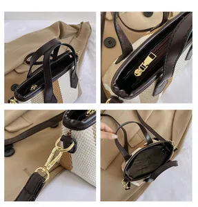 Detail view of woven striped handbag showing zipper closure and detachable leather strap