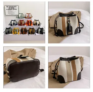Detail showing high-quality canvas stripes and leather stitching of the bucket bag