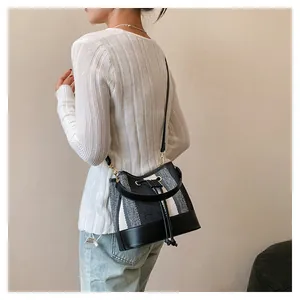 Λεπτομέρεια τσάντας bucket από tweed με μαύρο δερμάτινο κορδόνι και χρυσά μεταλλικά στοιχεία