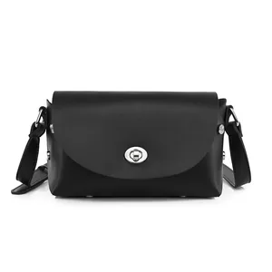 Minimalist black leather crossbody bag with silver rotating clasp on white background