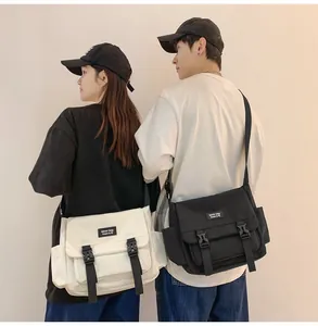 Sacs bandoulière en toile de style japonais en noir et crème portés par deux mannequins