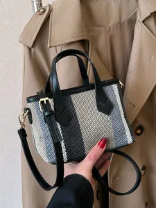 Fashionable striped canvas crossbody bag with leather handles and gold-tone hardware detail