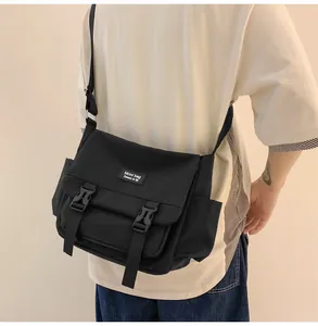 Détail du sac bandoulière en toile noire avec sangle réglable et boucle de fermeture