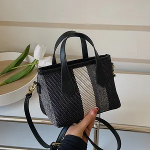 Modern striped woven bucket bag with black leather handle and detachable gold-tone hardware