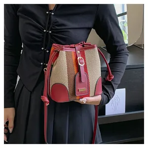 Detail of colorful striped bucket bag showing woven texture and red leather strap