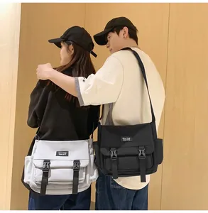 Deux modèles portant des sacs bandoulière techwear noirs et gris dans un cadre décontracté