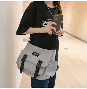 Détail du sac messager gris clair techwear avec boucles noires et poche latérale
